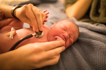 Midwife checking newborn baby at home
