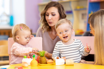 Children toddlers boy and girl playing in kindrgarten