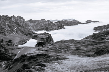 Fototapeta premium Aerial view over cloud and alpine valley and Trubsee lake of Titlis in Engelberg, Switzerland