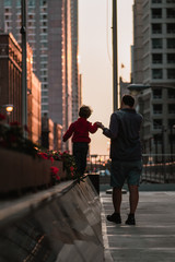 father and son walking in city
