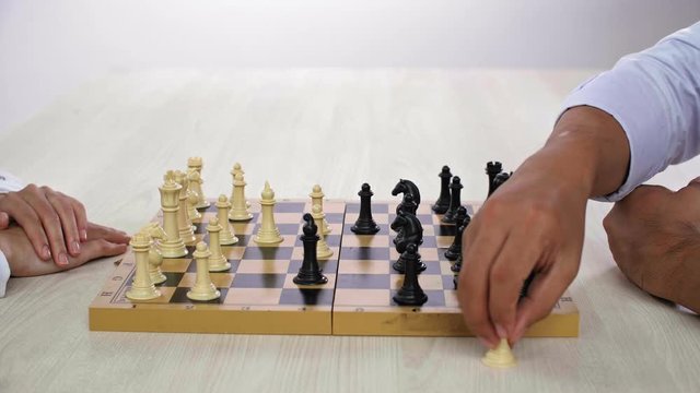Close up of male and female hands playing chess