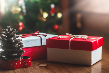 Two gift box on wooden table at Christmas tree background.Christmas concept