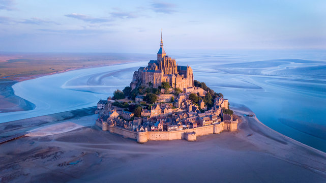 Aerial view of Mont Saint-Michel by river against sky during sunset