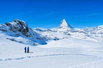 Hikers in the snow seeingg beautiful view of  Matterhorn Mountain, Zermatt, Switzerland.