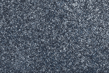 Dark gray sparkling background from small sequins, closeup. Brilliant backdrop.