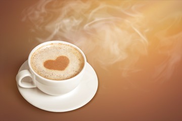 Coffee with heart shaped foam on wooden background