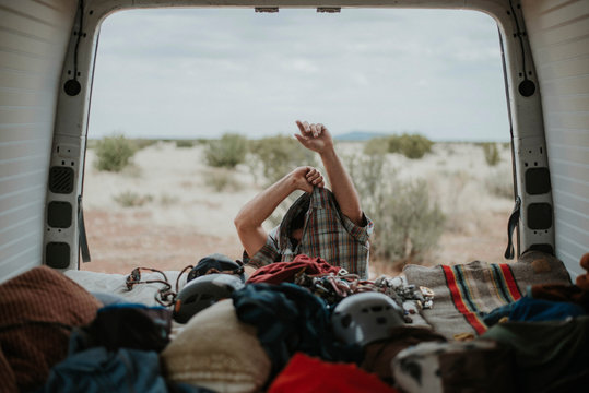 Man removing shirt near motorhome