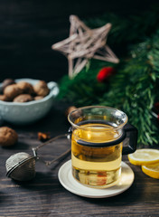 cup of tea on wooden table with blurred christmas tree in background
