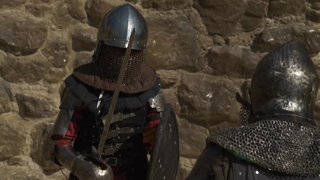 slow motion duel of two knights in iron helmets