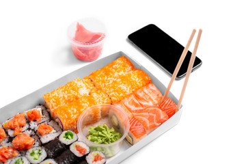 sushi set rolls on white background chopsticks wasabi ginger phone delivery food concept