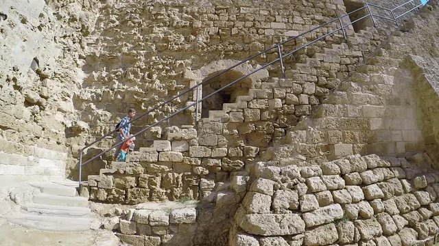Father and his toddler son travelers climbs up stairs on medieval fortress wall, Famagusta,   Venetian Othello Castle. Landmarks of Cyprus.