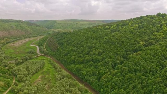 Amazing aerial view of the forest mountain with small village and river valley