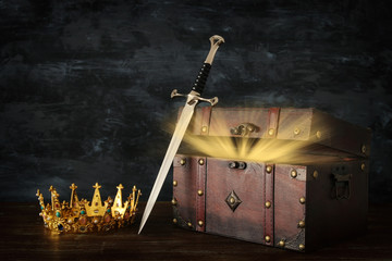 low key image of beautiful queen/king crown, open chest with treasure and sword. fantasy medieval...