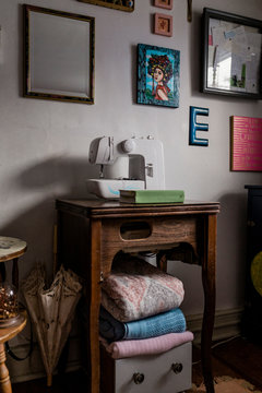 Picture frames hanging on wall over sewing machine at home
