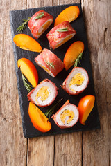 Baked roll pork tenderloin stuffed with persimmon and cheese wrapped in prosciutto close-up....