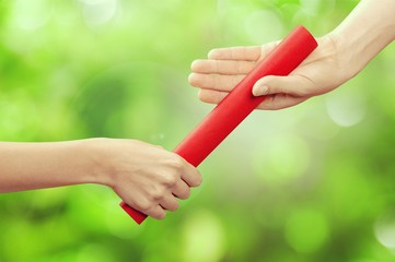 Close-up of relay baton being passed