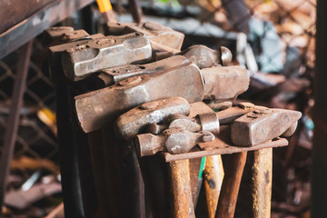 A collection of metallic hammers in a blacksmith shop