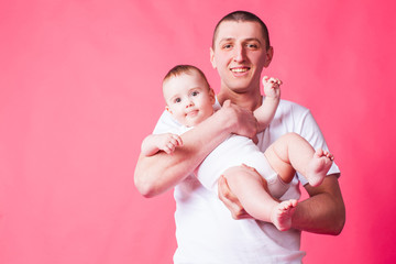 Faher and baby portrait on a pink background