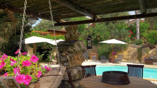 Beautiful garden of luxury resort in Italy with swimming pool traveling shot through flowers