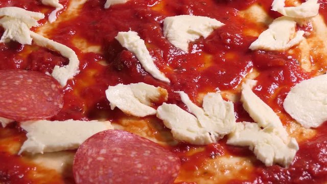 Preparing pizza toping. Laying fresh spinache leaves on pizza topping.