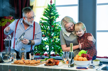 Father, daughter and grandson in the kitchen cook Christmas food