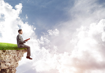 Student guy in suit with book in hands preparing for exam