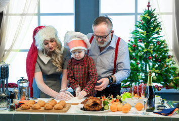 Grandfather, mother and son in the kitchen cook Christmas food