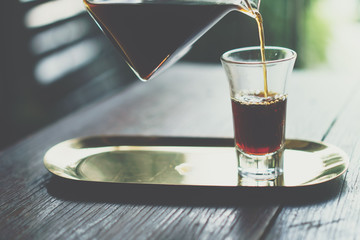 Black coffee or Americano on table with film vintage tone background.