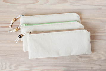 Handmade cotton pencil cases with beads on the wooden table