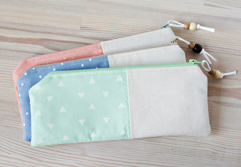 Handmade cotton pencil cases with beads on the wooden table
