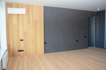 Modern interior house room with wooden floringa, wooden wall decoration, radiator and air...