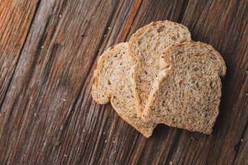 Whole wheat, whole grains bread on dark wooden board, close up, top view