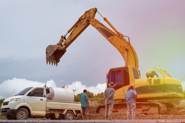 Naklejka premium Group of men and backhoe on construction site. with sun light