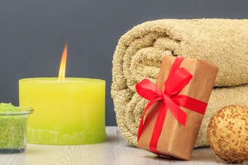 Fototapeta na wymiar Spa composition with towel, gift box, sea salt and candle.