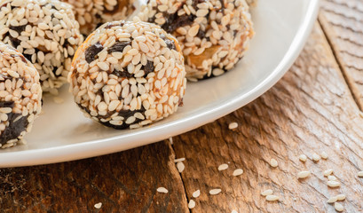 Close-up energy balls handmade on white plate on wooden table. Sselective focus.