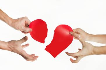 The hands of people tearing the heart apart. Valentine's day concept. Torn heart. On isolated background