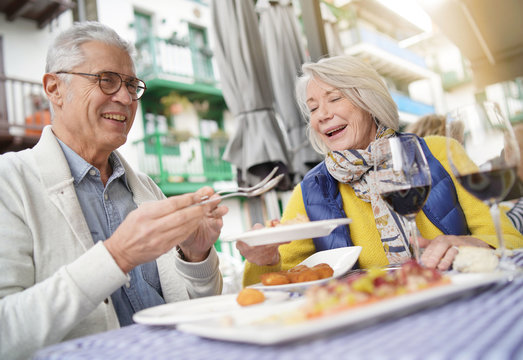 Attractive Senior Couple Eating Tapas Outdoors