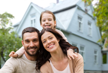 family, real estate and accommodation concept - happy mother, father and little daughter over house...