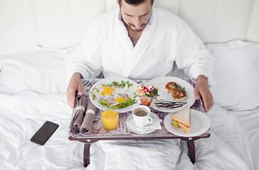 Obraz na płótnie Canvas Breakfast in bed for bearded dark-haired sexy manly man
