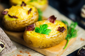 baked potato stuffed with cheese and bacon on paper on wooden background