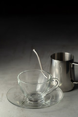 Glass of coffee and Stainless steel pitcher on the cement table
