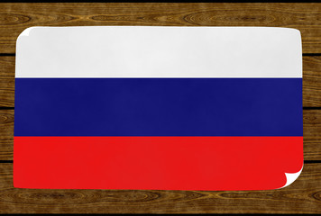 Illustration of a Rusian flag on the paper pasted on the woody wall