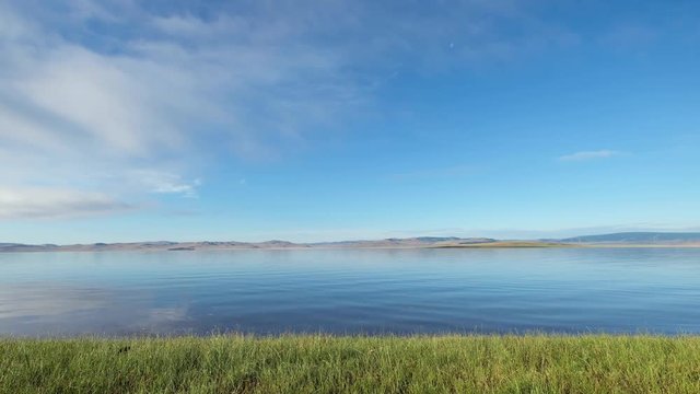 Calm waters of mongolian lake Telmen Lake surrounded by hills and deserts in north Mongolia