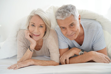 Portait of happy attractive senior couple in bed