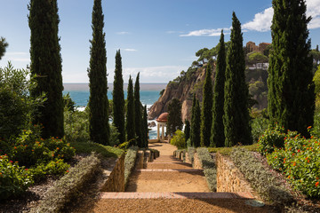 Alley / Way at the coastline to the ocean of the Costa Brava, Spain, against blue sky