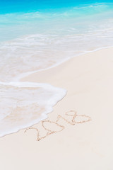 2018 inscription written on sandy beach, New Year greeting card.