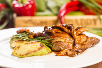 Braised duck leg with mushrooms and fried zucchini and rosemary