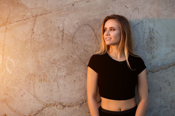 Horizontal portrait of beautiful smiling blonde woman on outdoor wall background