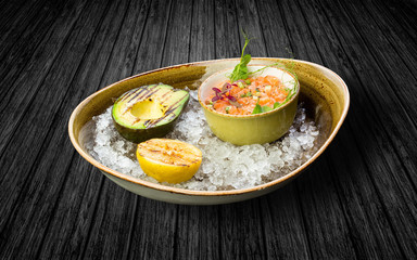 Marinated salmon with avocado and lemon. On ice
