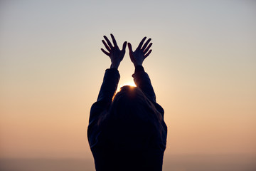 Woman with arms wide open enjoying the sunrise / sunset time.